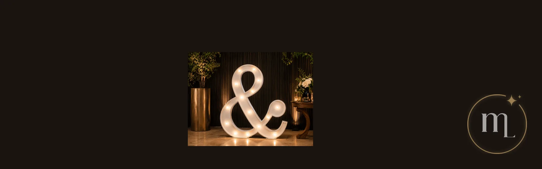 Un ampersand iluminado apoyado en el piso, con el reflejo de sus focos
